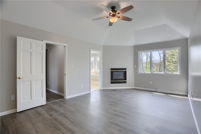 unfurnished living room featuring ceiling fan, a glass covered fireplace, wood finished floors, lofted ceiling, and visible vents