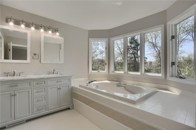 bathroom featuring a sink, double vanity, and a bath