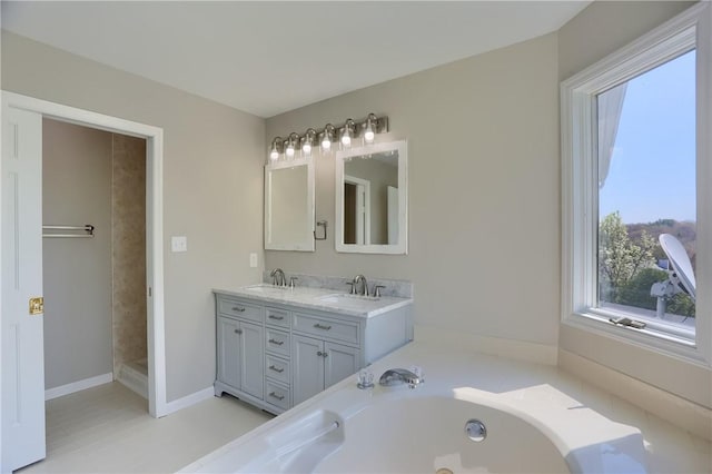 full bathroom with double vanity, a tub, and a sink