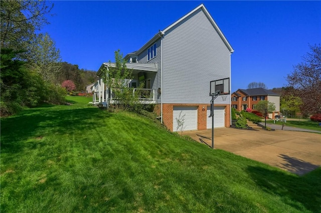 view of side of property featuring an attached garage, a lawn, and driveway