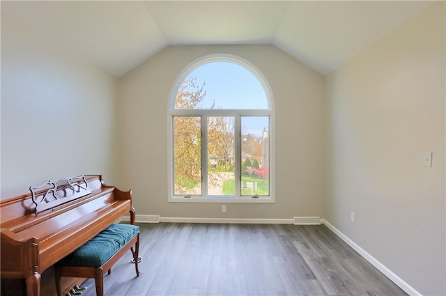 sitting room featuring baseboards, visible vents, wood finished floors, and a wealth of natural light