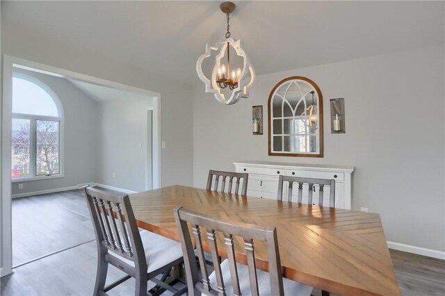 dining area featuring baseboards, wood finished floors, and a chandelier