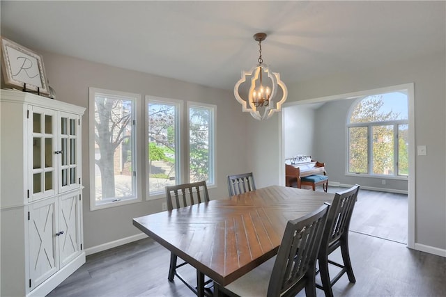 dining space featuring a healthy amount of sunlight, wood finished floors, and a chandelier