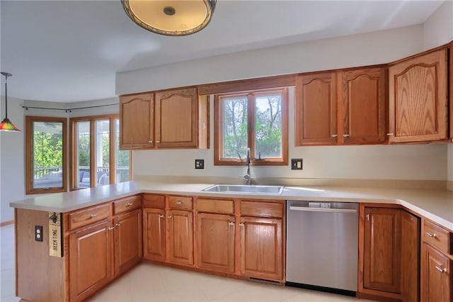 kitchen featuring a sink, plenty of natural light, a peninsula, and dishwasher
