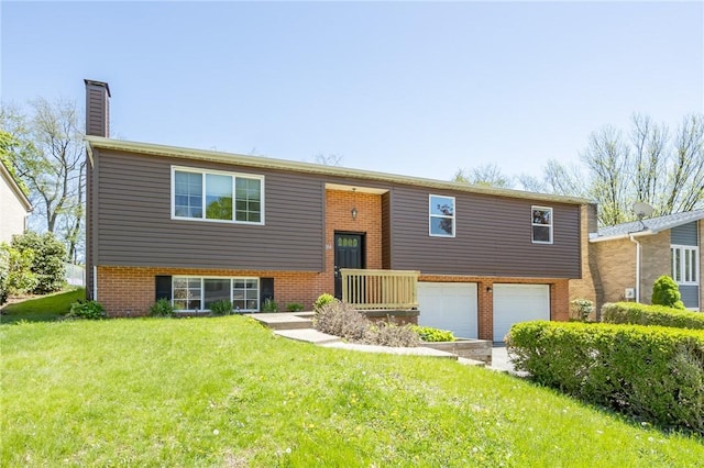 raised ranch with an attached garage, a front lawn, a chimney, and brick siding