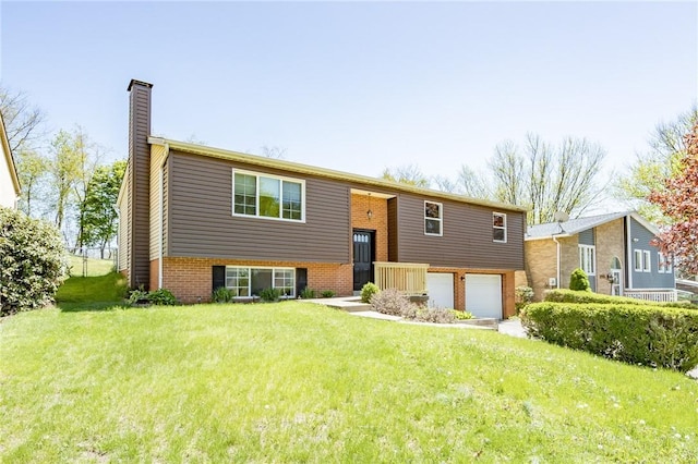 split foyer home featuring brick siding, a garage, a front yard, and a chimney