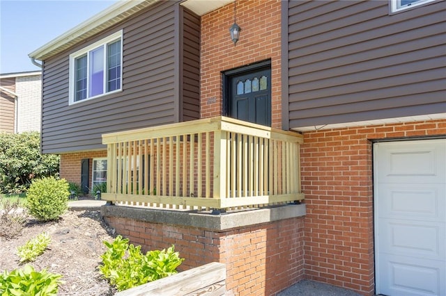 doorway to property with brick siding and a garage