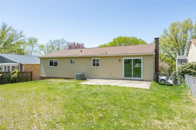 rear view of house featuring a chimney, central AC unit, a patio area, fence, and a yard
