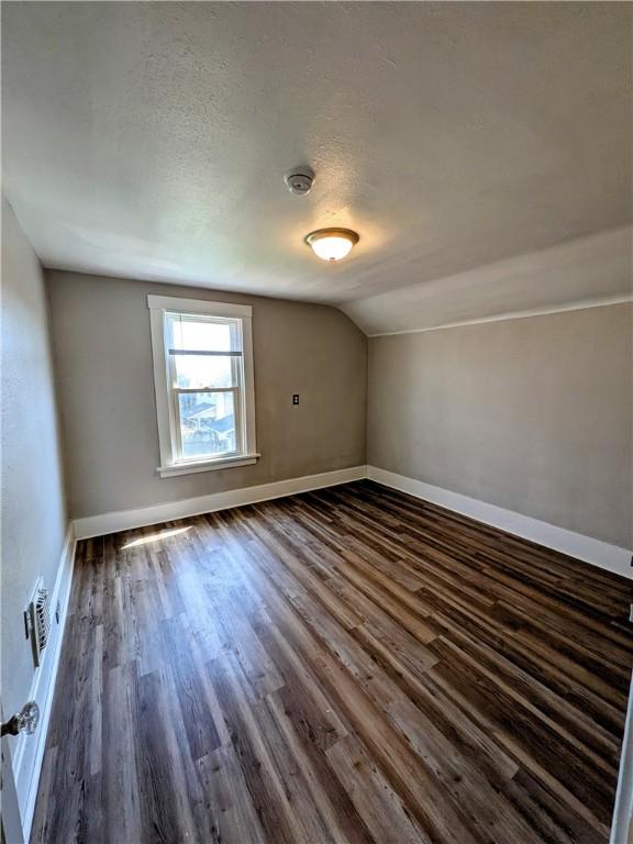 108 Mccandless St, Arnold, PA 15068 - additional living space with baseboards, dark wood-style flooring, a textured ceiling, and lofted ceiling