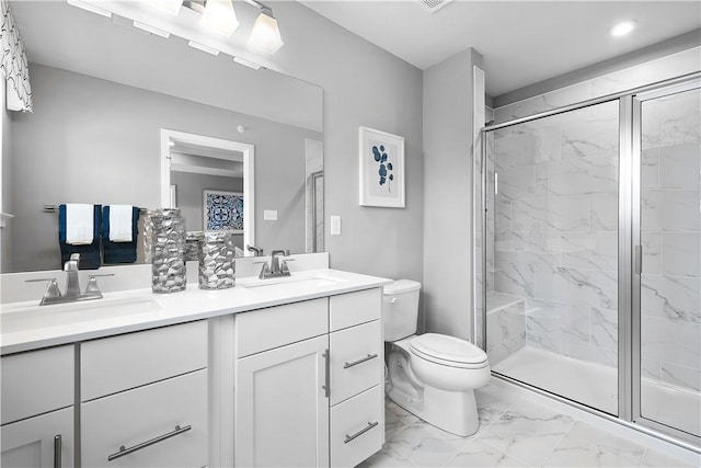 full bath featuring double vanity, a sink, toilet, marble finish floor, and a marble finish shower