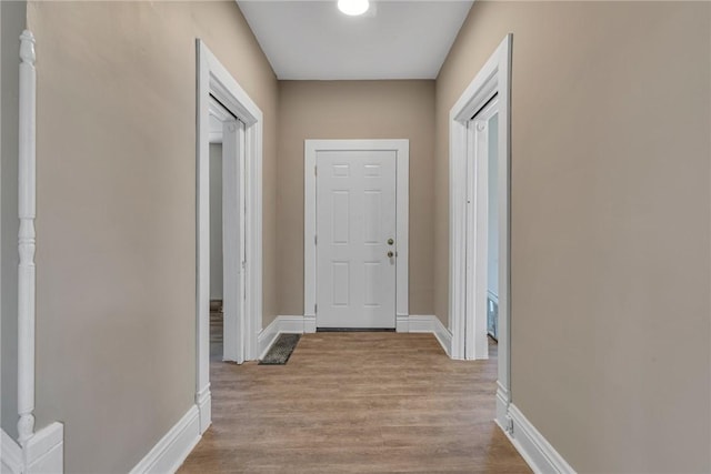 hallway with light wood-style floors and baseboards