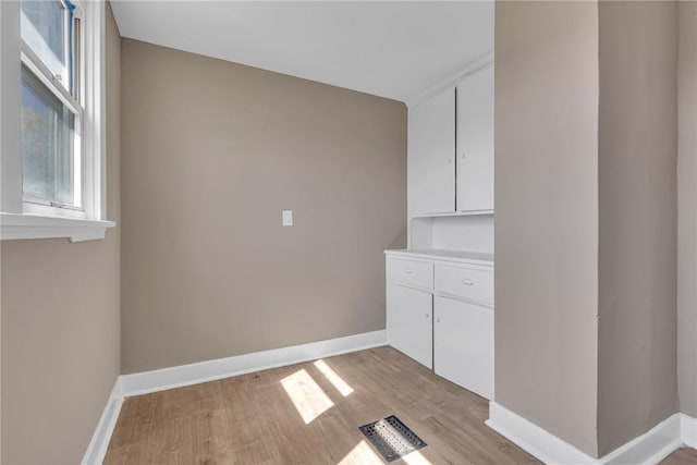 washroom with baseboards and light wood-style flooring