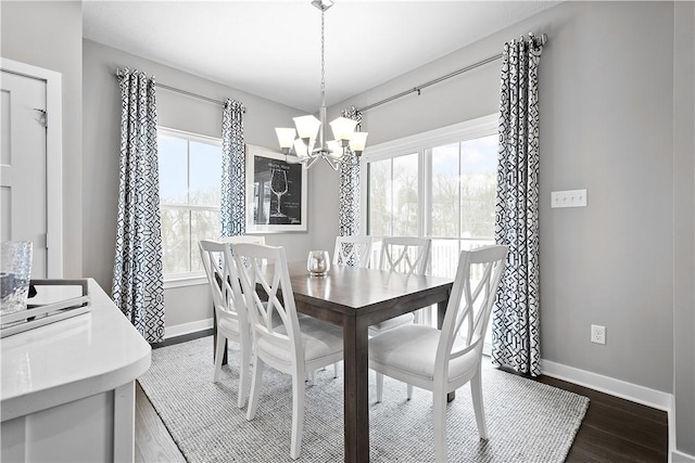 dining room with an inviting chandelier, baseboards, and dark wood-style flooring