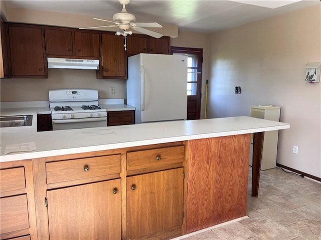 kitchen with a peninsula, white appliances, ceiling fan, light countertops, and under cabinet range hood