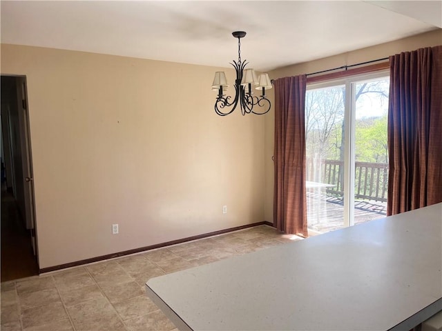 unfurnished dining area with baseboards and a chandelier