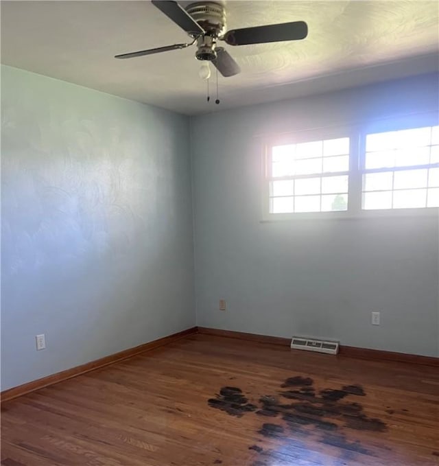 unfurnished room with baseboards, ceiling fan, wood finished floors, and visible vents