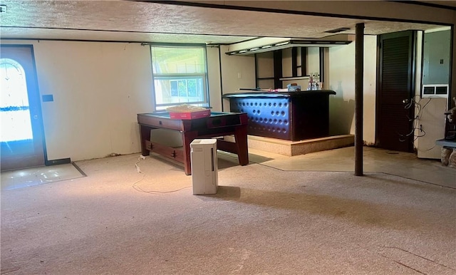 basement featuring carpet floors, plenty of natural light, and a textured ceiling