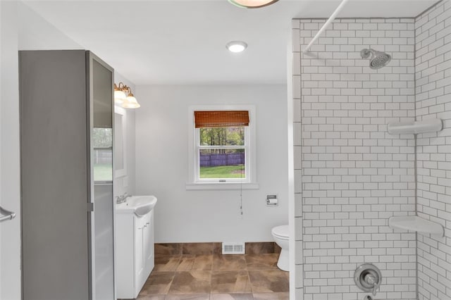 bathroom featuring visible vents, a shower, toilet, and vanity