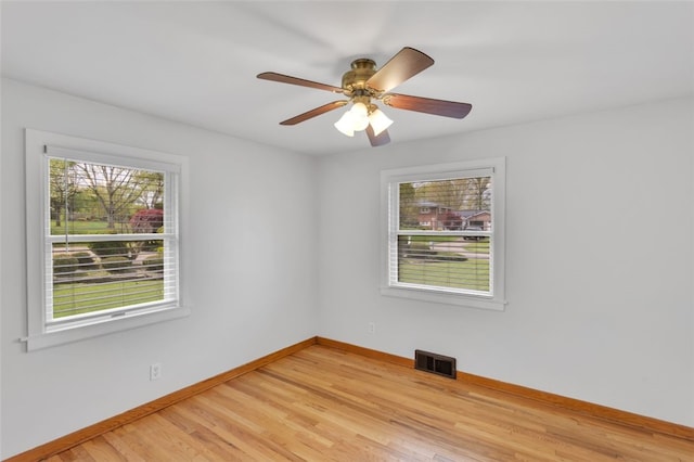 empty room with visible vents, baseboards, ceiling fan, and light wood-type flooring