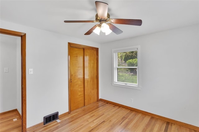 unfurnished bedroom with ceiling fan, visible vents, baseboards, a closet, and light wood-style floors