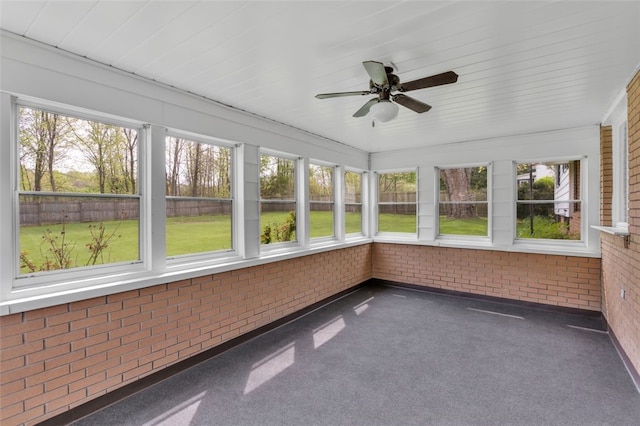 unfurnished sunroom with brick wall, plenty of natural light, and carpet