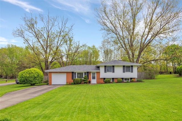 tri-level home featuring fence, an attached garage, driveway, and a front yard