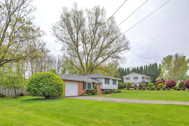 tri-level home featuring a garage, driveway, a front lawn, and brick siding