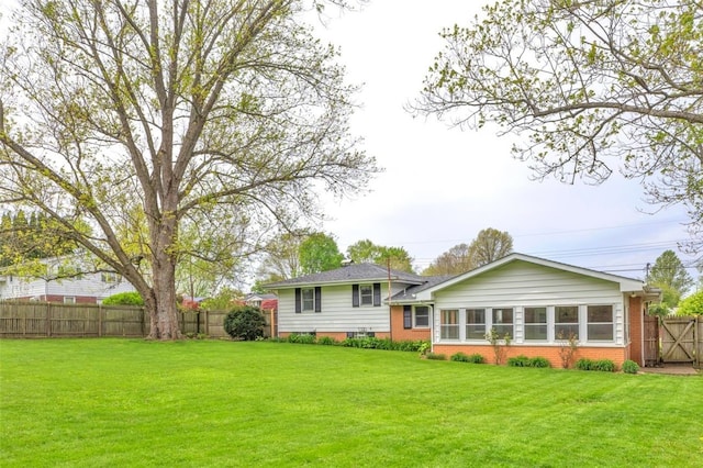 back of property featuring a lawn, brick siding, and fence private yard