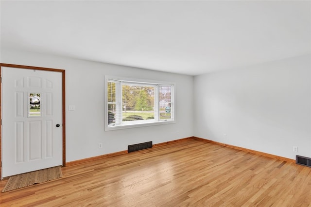 foyer with baseboards, visible vents, and light wood-style floors