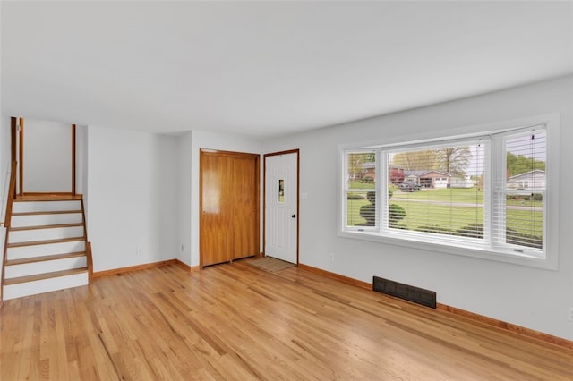 interior space featuring stairs, baseboards, visible vents, and light wood-type flooring