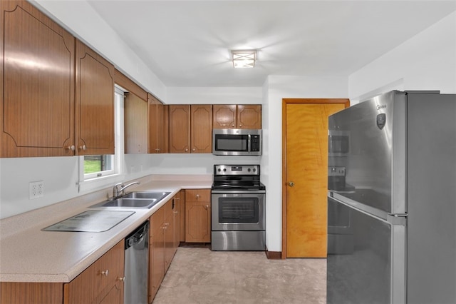 kitchen featuring a sink, light countertops, brown cabinetry, and stainless steel appliances