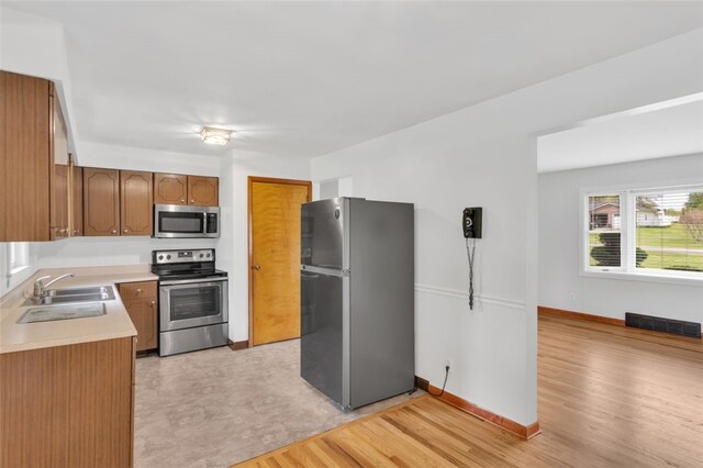 kitchen featuring visible vents, baseboards, light countertops, a sink, and appliances with stainless steel finishes
