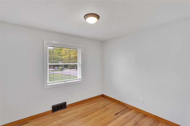 unfurnished room with light wood-style floors, baseboards, and visible vents