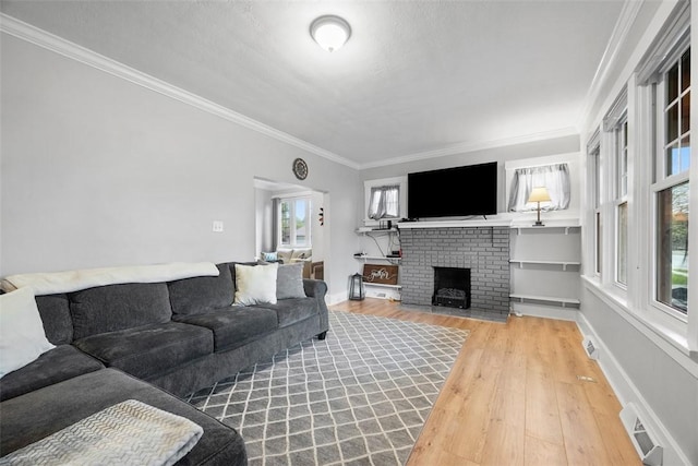 living room featuring visible vents, ornamental molding, wood finished floors, and a fireplace