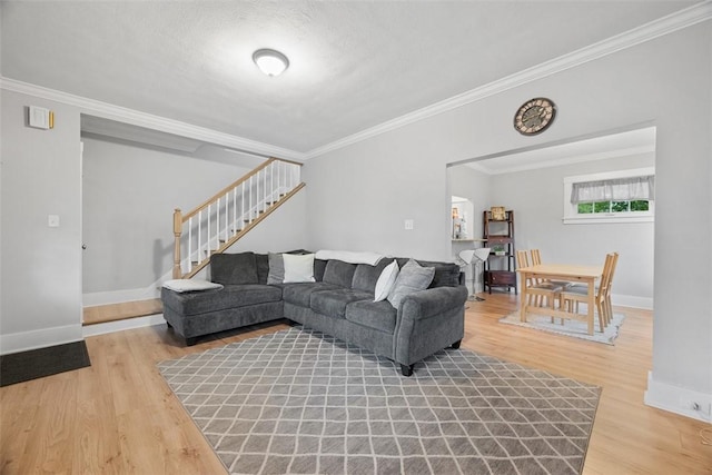 living room featuring ornamental molding, stairs, and wood finished floors