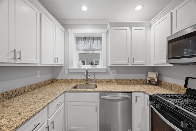 kitchen featuring recessed lighting, a sink, appliances with stainless steel finishes, and white cabinets