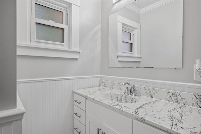 bathroom with wainscoting, ornamental molding, and vanity