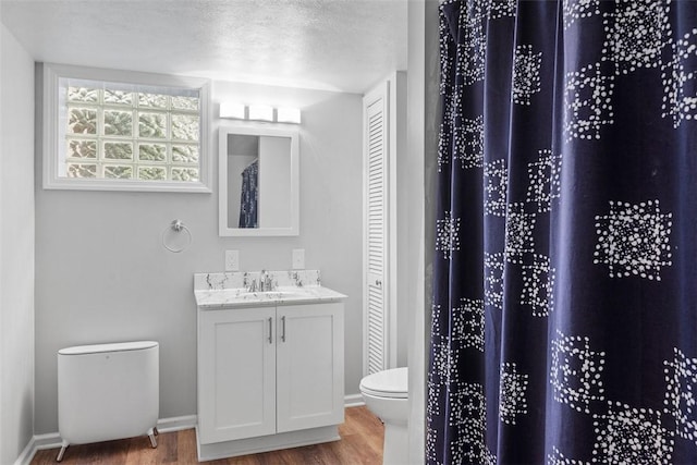 bathroom featuring vanity, baseboards, toilet, and wood finished floors