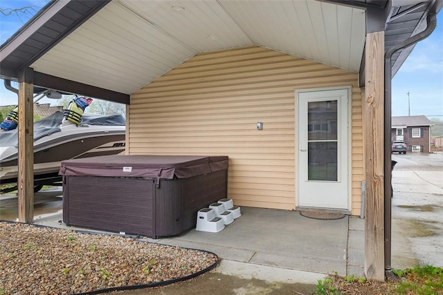 view of patio / terrace featuring a carport and a hot tub