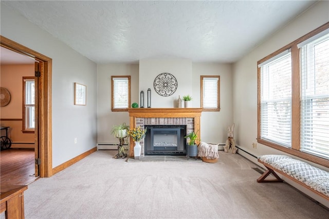living room with baseboards, a baseboard heating unit, carpet, and a fireplace