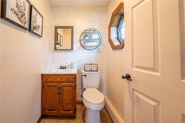 half bath featuring vanity, baseboard heating, and toilet