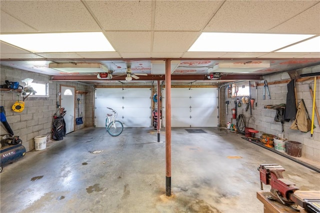 garage featuring concrete block wall and a garage door opener