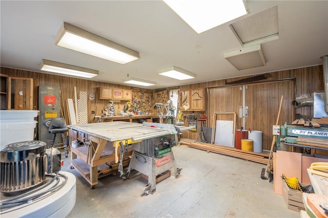 interior space featuring wooden walls, a workshop area, and concrete flooring