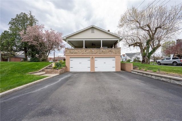 exterior space featuring a ceiling fan and aphalt driveway