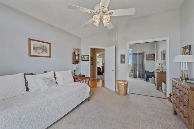 bedroom with ceiling fan, light colored carpet, high vaulted ceiling, visible vents, and a closet