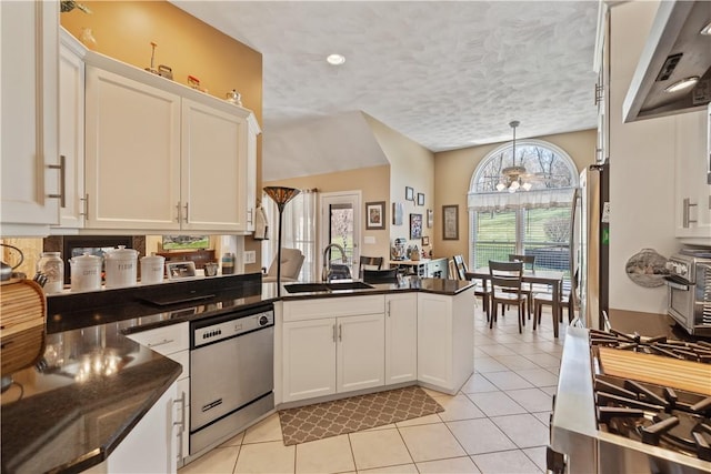 kitchen featuring an inviting chandelier, light tile patterned flooring, white cabinetry, a sink, and appliances with stainless steel finishes
