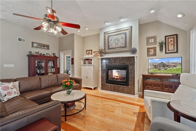 living area with visible vents, recessed lighting, a high end fireplace, a ceiling fan, and light wood finished floors