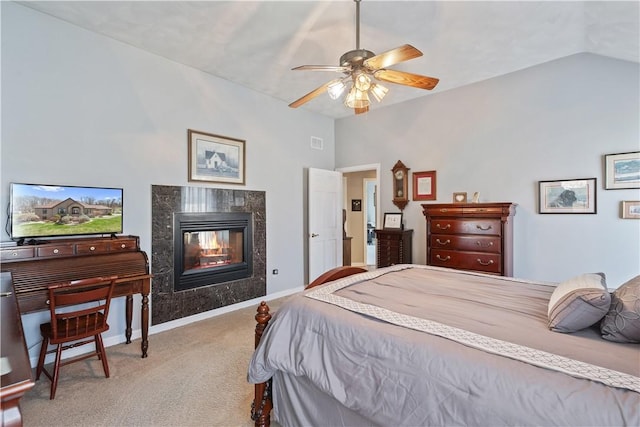 bedroom featuring ceiling fan, visible vents, a high end fireplace, vaulted ceiling, and carpet