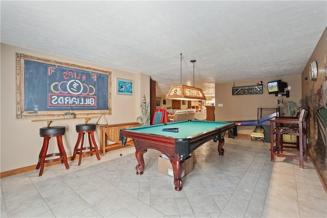 game room featuring light tile patterned floors, billiards, and a textured ceiling