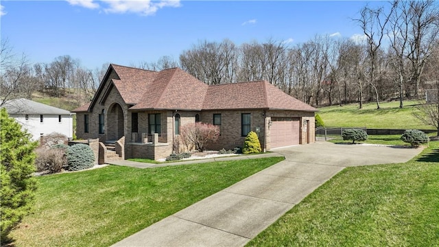 view of front of house featuring fence, a front yard, brick siding, an attached garage, and driveway